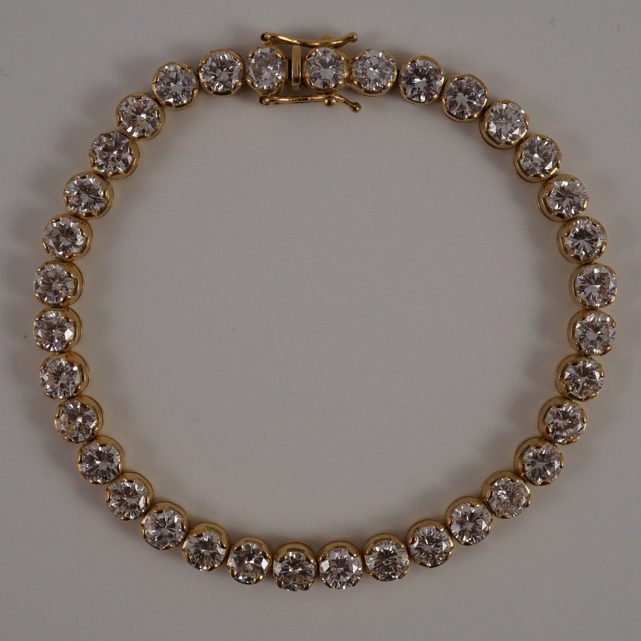 A modern 18k gold and round brilliant cut diamond set line bracelet